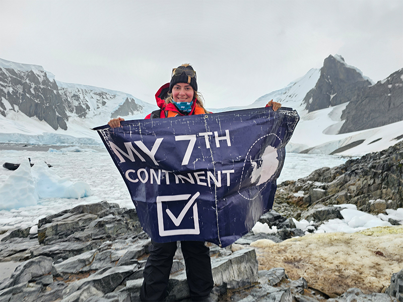 Kasey with her 7th continent flag in Antarctica
