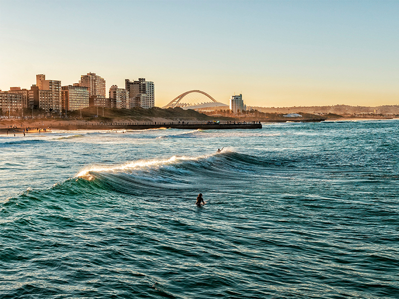 Surfers enjoy sunset waves